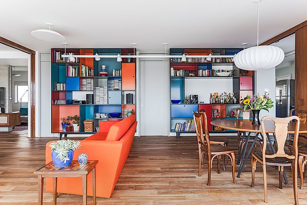 Dominantou obývacího pokoje spojeného s jídelnou je dvojice skříní v sytých živých barvách.
