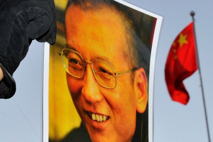 Plakát s fotografíí Lioua Siao-poa v rukou demonstranta před čínskou ambasádou v norském Oslu