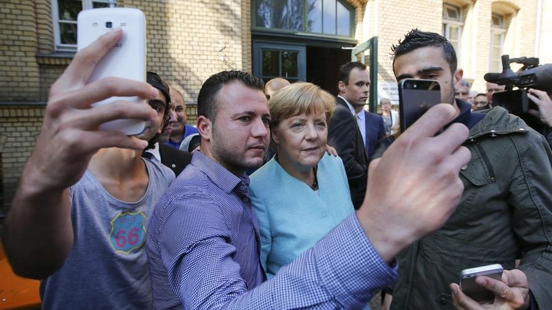 Migranti si pořizují selfie s německou kancléřkou Angelou Merkelovou před centrem pro uprchlíky v Berlíně. Snímek z 10. září 2015