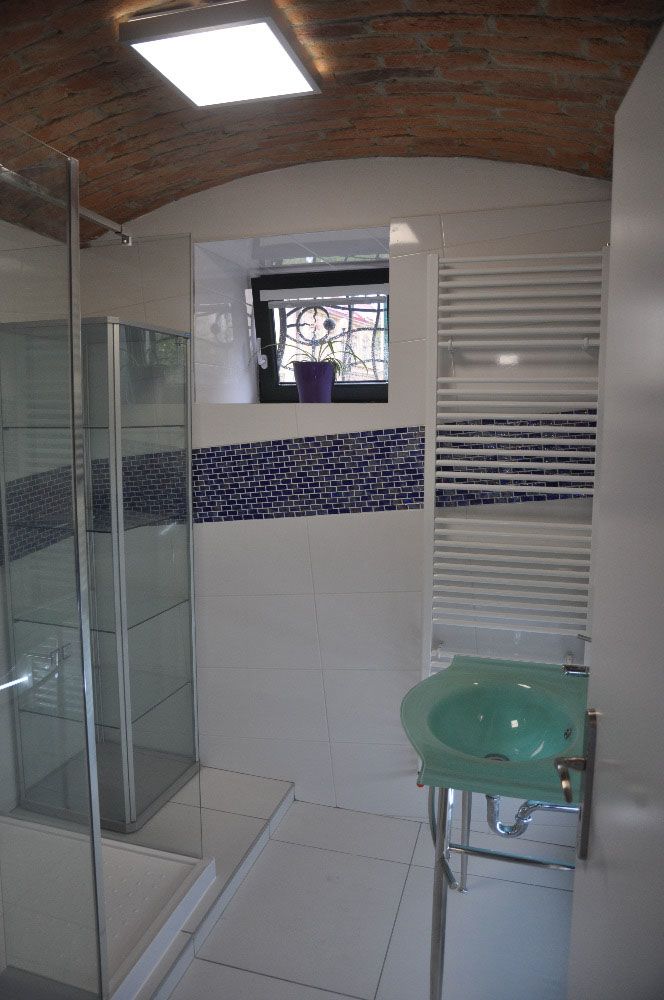Minimalisticky zařízenou koupelnu ozvláštňují šikmo orientované obklady na zdech.