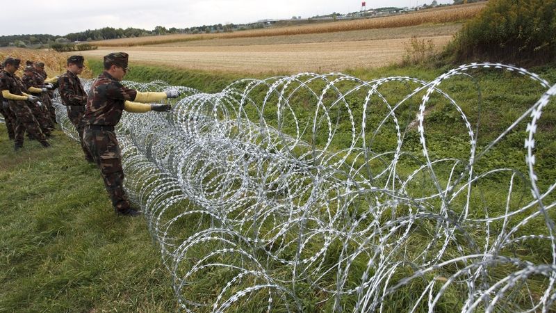 Maďarští vojáci pokládají žiletkový drát na maďarsko-slovinské hranici