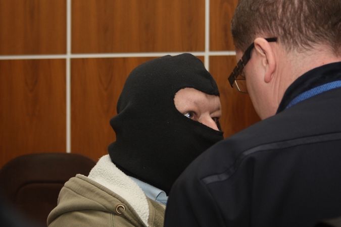 Antonína Dolíhala (vlevo) přivedla k soudu eskorta se zahalenou tváří.