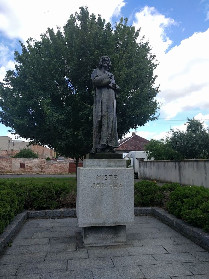 Pomník Mistra Jana Husa před jeho jubilejním kostelem v Pečkách.