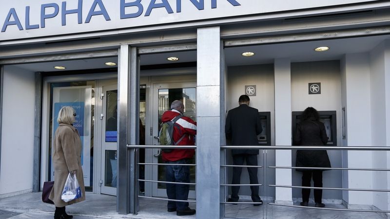 Lidé vybírají peníze z bankomatů Alpha Bank v Aténách