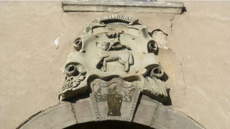 Reliéf beránka s praporem v kartuši nad vstupním portálem symbolizuje vlastnictví Jednoty bratrské.