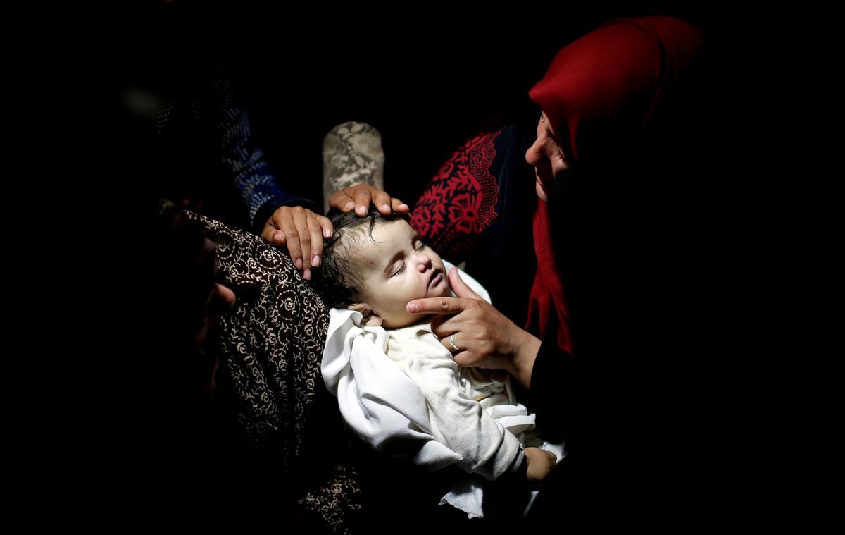 Příbuzní truchlí u těla osmiměsíčního palestinské dívenky Laily al-Ghandourové během jejího pohřbu v Gaze.