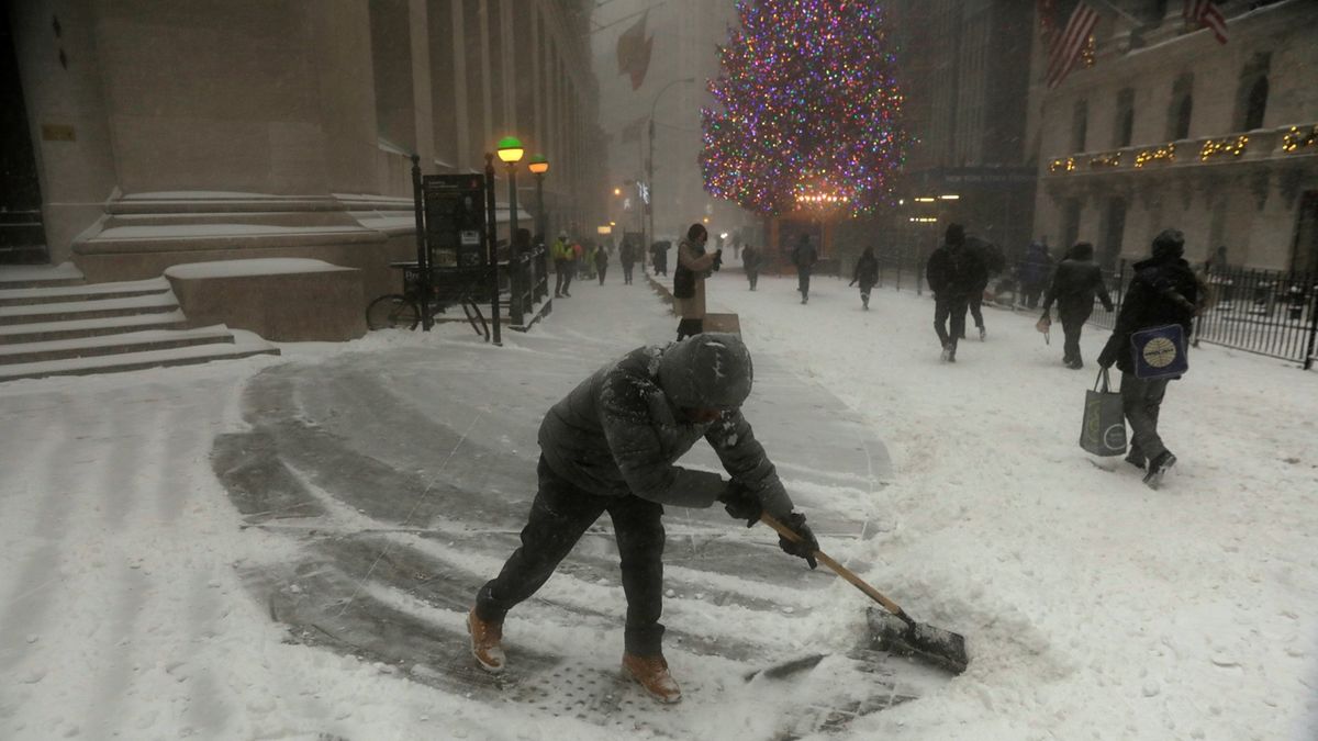 Muž odklízí sníh u newyorské ulice. 