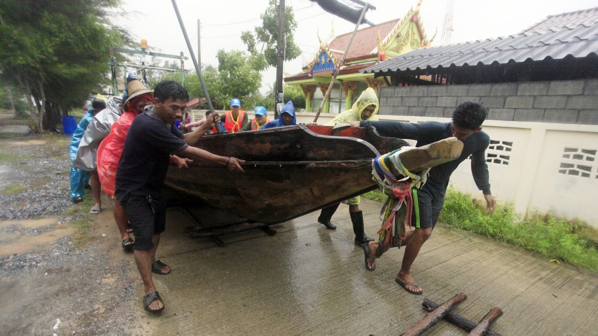Thajští rybáři odtahují do bezpečí před bouří loď.