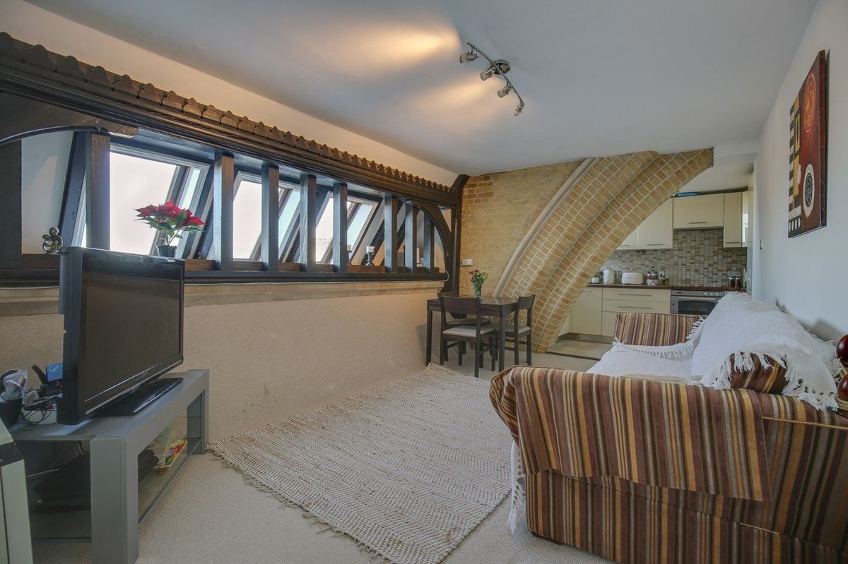 Obývací pokoj za obloukem navazuje na kuchyň malým jídelním koutem.