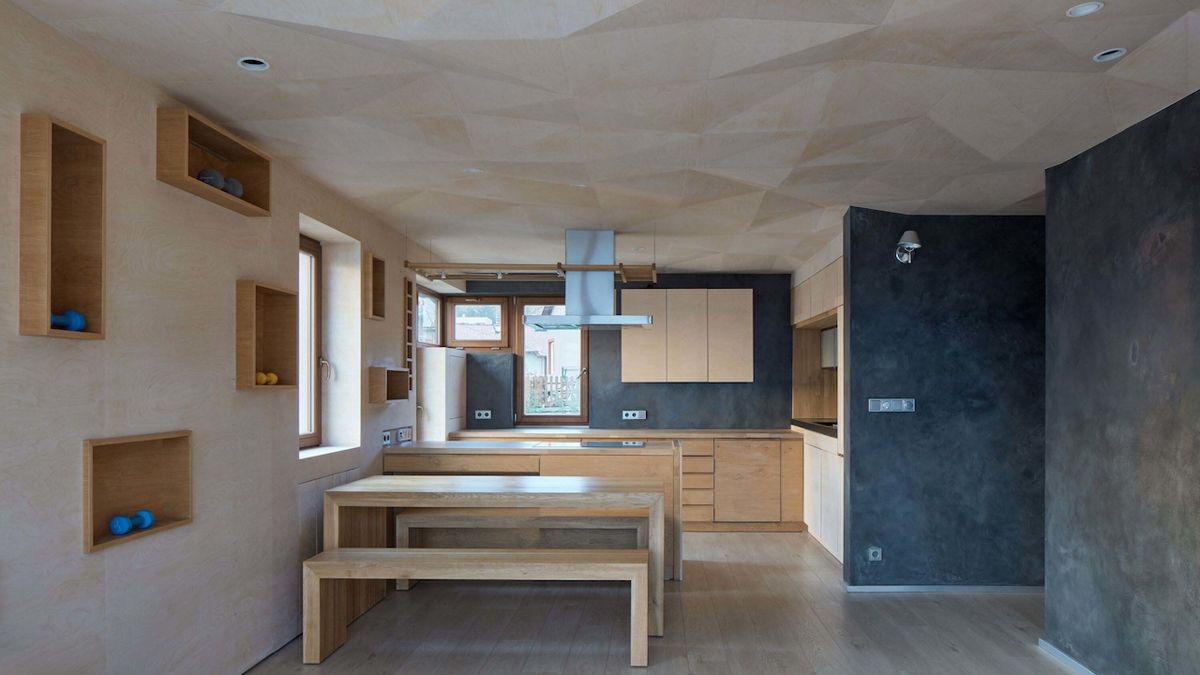 V interiéru jsou přítomny tři základní materiály: tmavá cementová stěrka, dřevo dub a bělená březová překližka.