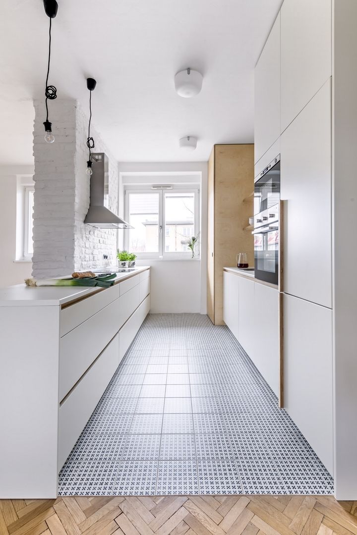 Kuchyňský nábytek je zhotovený podle autorského návrhu architektů z lakované MDF desky. Bílou barvu oživuje jemný vzor dlažby (Vives) a kontrastní skříň z překližky, kterou se prochází do spíže s oknem. 
