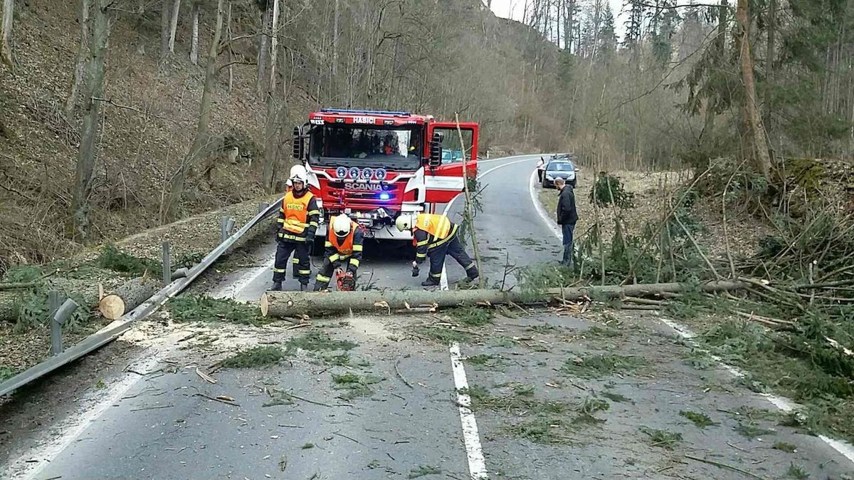 Na mnoha místech hasiči odstraňují spadlé stromy z komunikací.