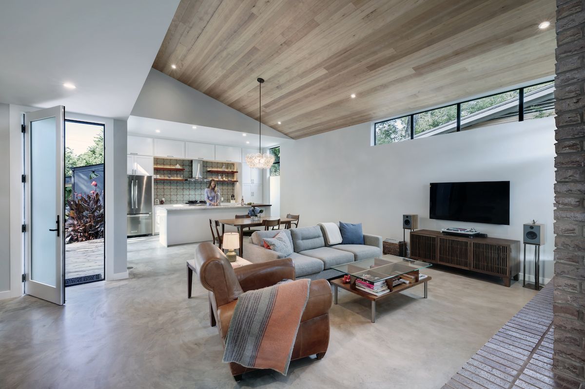 Hezkým prvkem v obývací zóně je konferenční stolek, tvořený trojicí materiálů použitých v celé místnosti - sklem, dřevem a kovem.