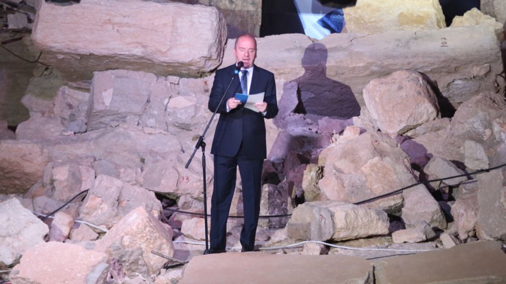Syrský ministr turismu Muhammad Martini hovoří na zřícených kamenech