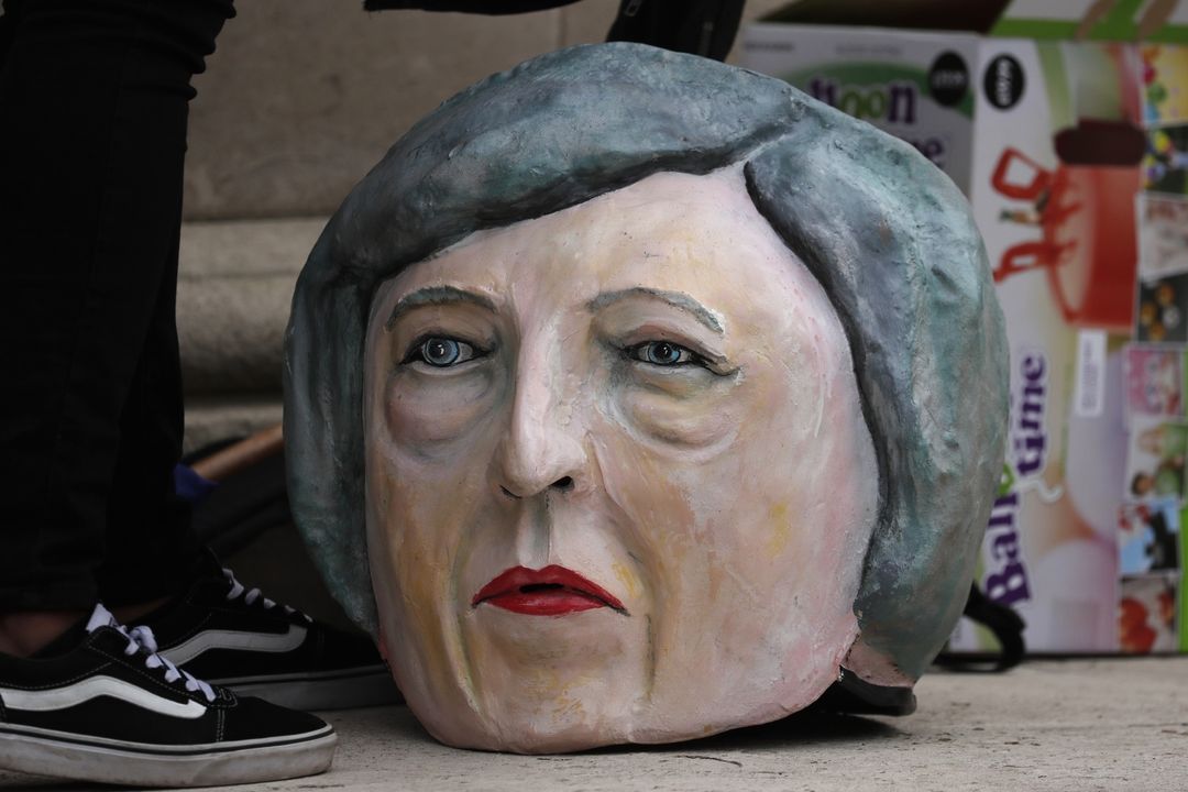 Maska britské premiérky Theresy Mayové u nohou aktivisty z organizace Avaaz