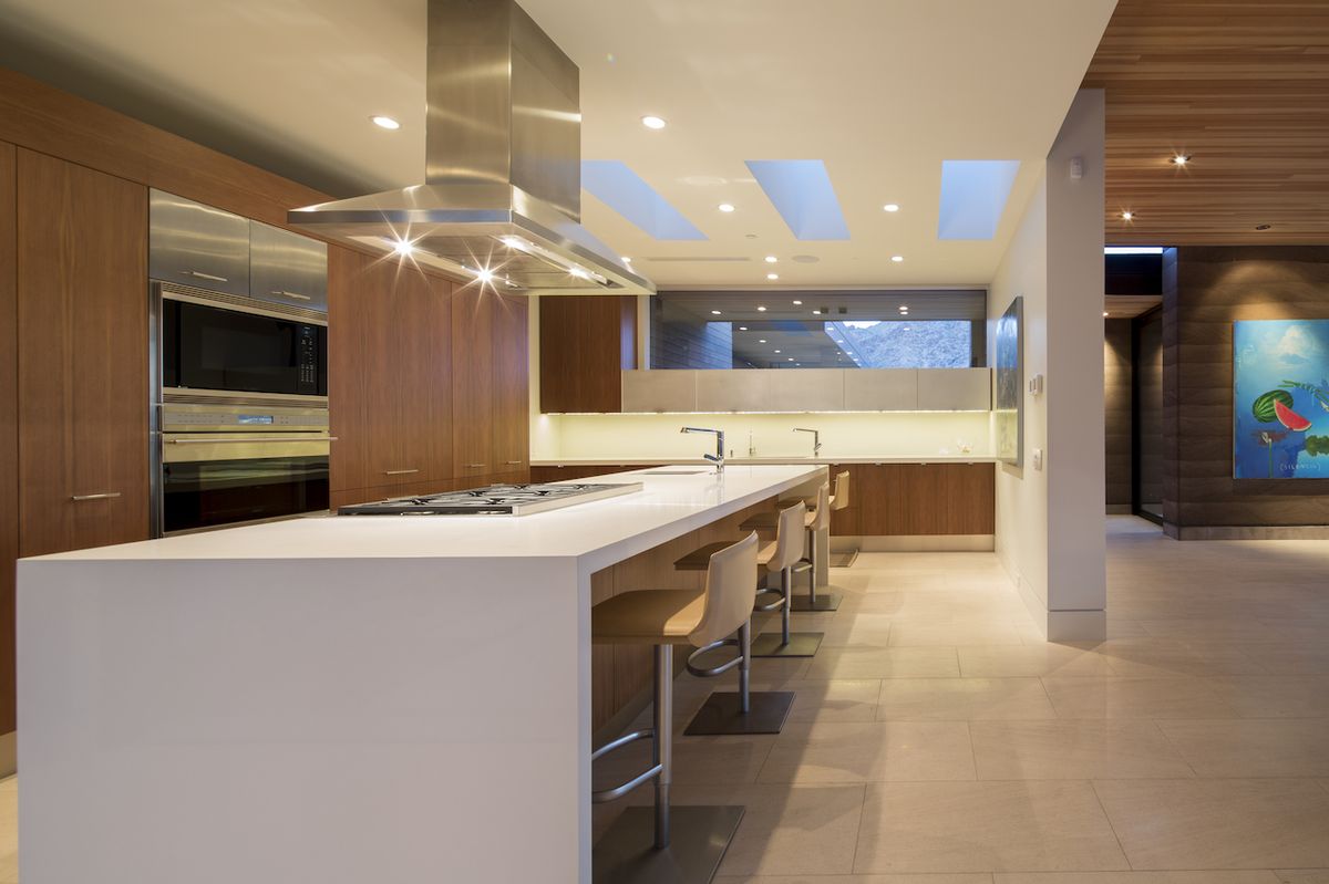 Prostorná kuchyň je zařízena v kombinaci hnědé abílé barvy.