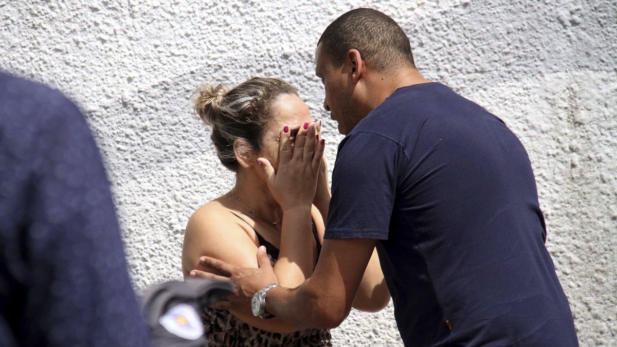 Muž utěšuje ženu u školy v Brazílii, kde se střílelo 
