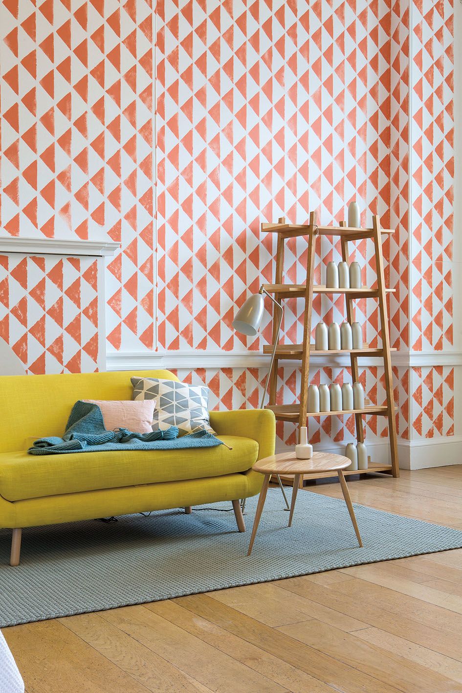 Oranžový retro vzor a žlutá sedačka dodávají obývacímu pokoji punc vitality. 