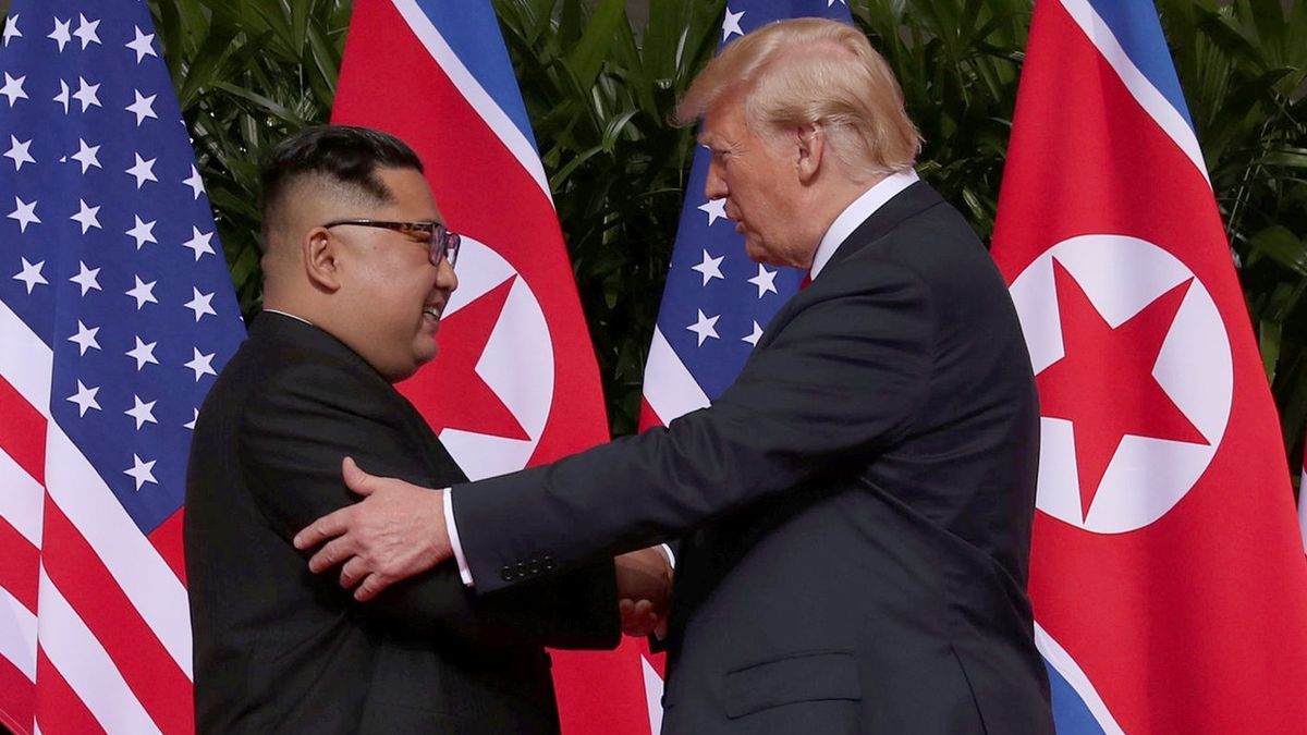 Americký prezident Donald Trump a severokorejský vůdce Kim Čong-un si na summitu v Singapuru podávají ruce.