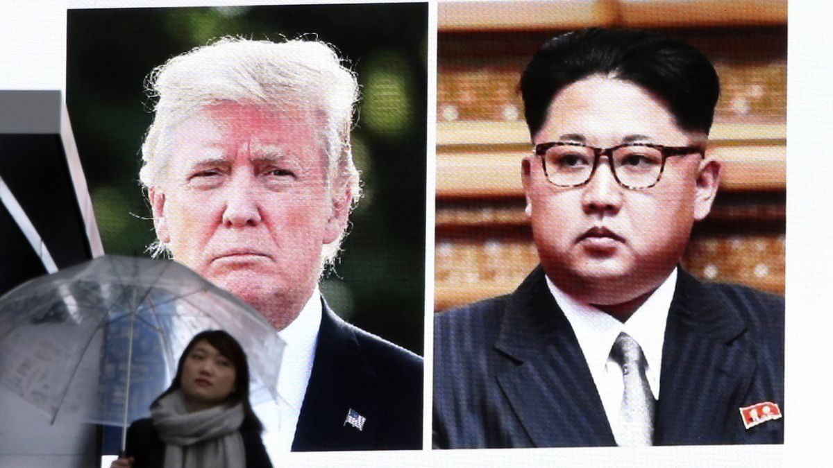 Žena v Tokiu prochází pod obří obrazovkou s portréty prezidenta USA Donalda Trumpa a severokorejského vůdce Kim Čon-una.