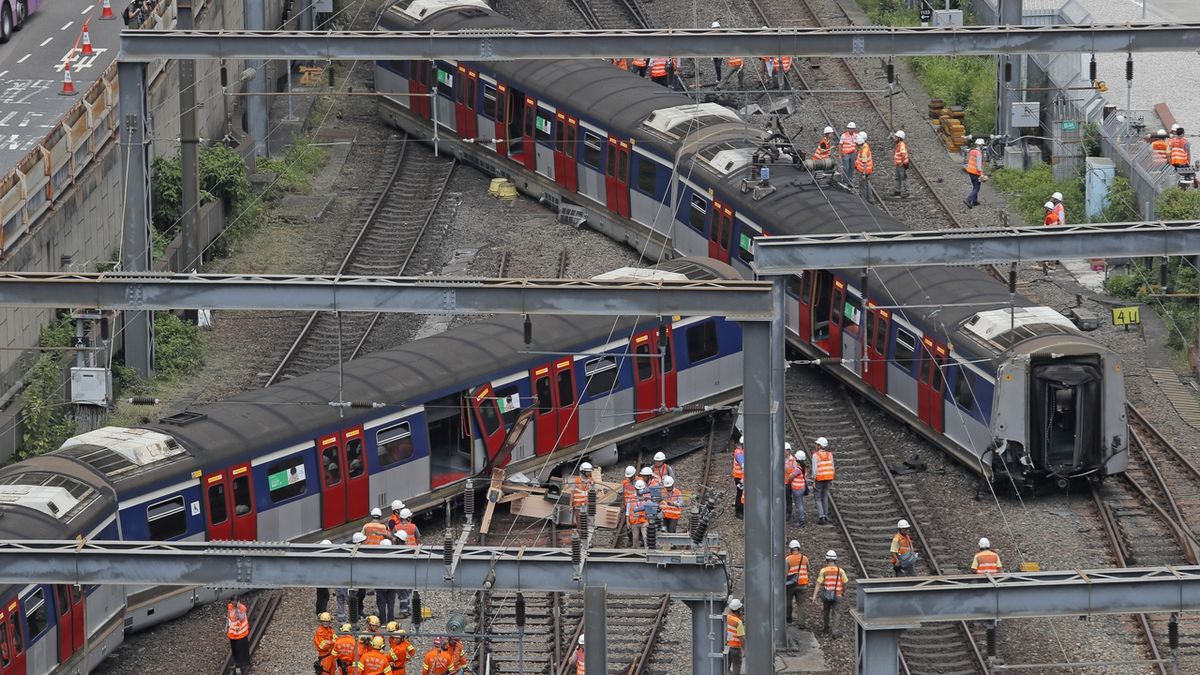 Zaměstnanci provozovatele MTR u vykolejeného vlaku metra v Hongkongu 