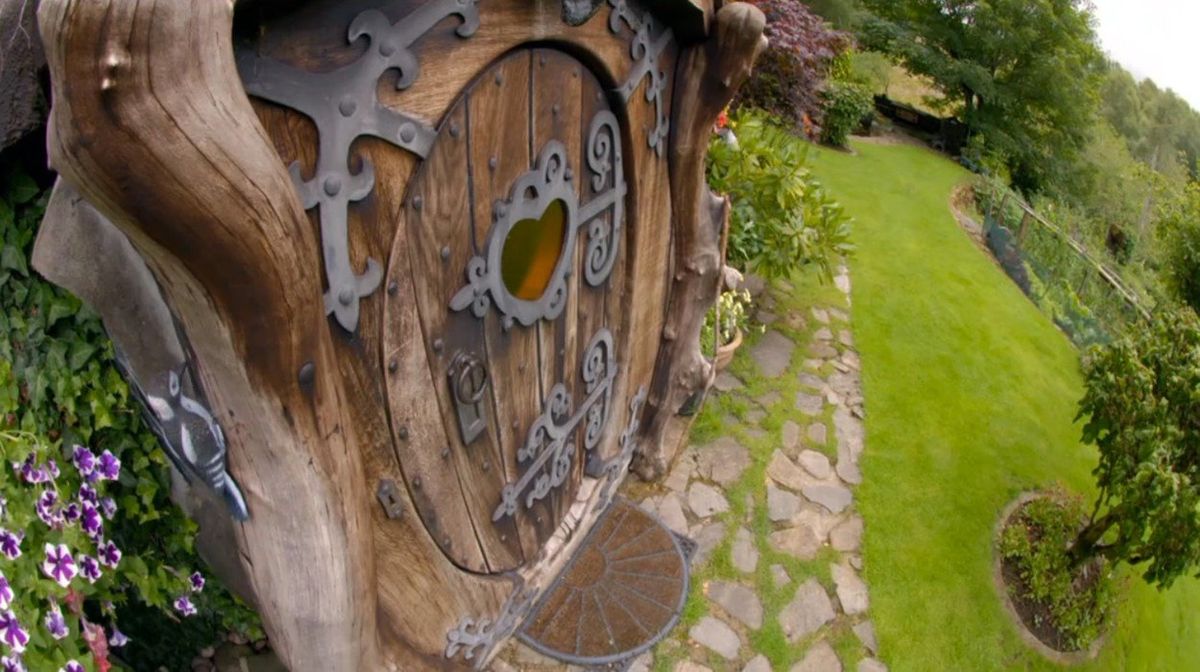 Oválný tvar dřevěných dveří zdobených kováním je jedním z prvků, jimiž se neplánovaně trefil do stylu hobitích domků.