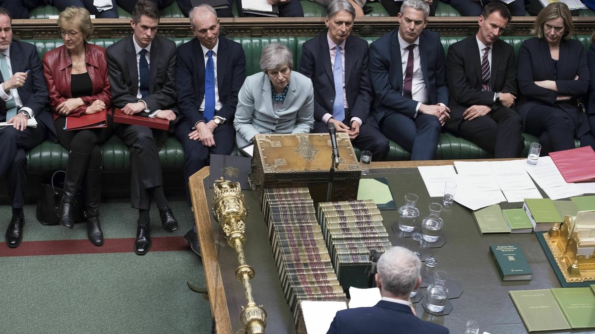 Britská ministerská předsedkyně Theresa Mayová sleduje projev politického oponenta Jeremyho Corbyna. 