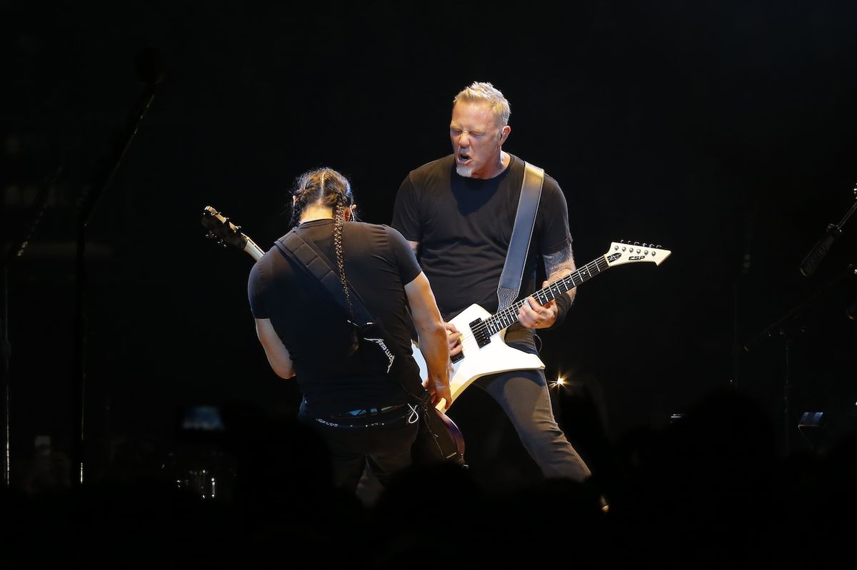 Robert Trujillo (zády) a James Hetfield na pódiu v Praze.