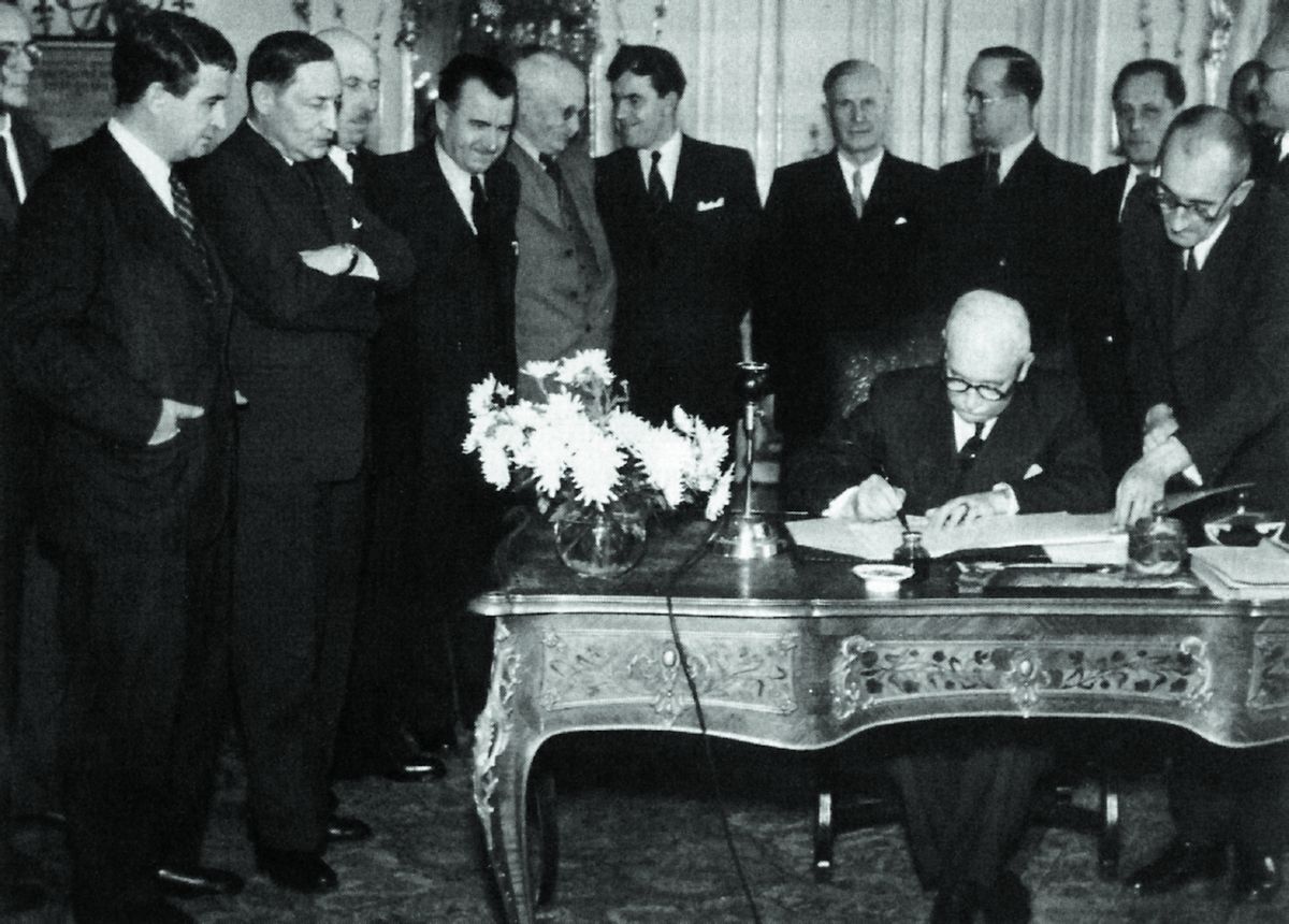 Bohumil Laušman (vlevo) přihlíží, jak prezident Edvard Beneš podepisuje 24. října 1945 dekrety o znárodnění klíčového průmyslu.