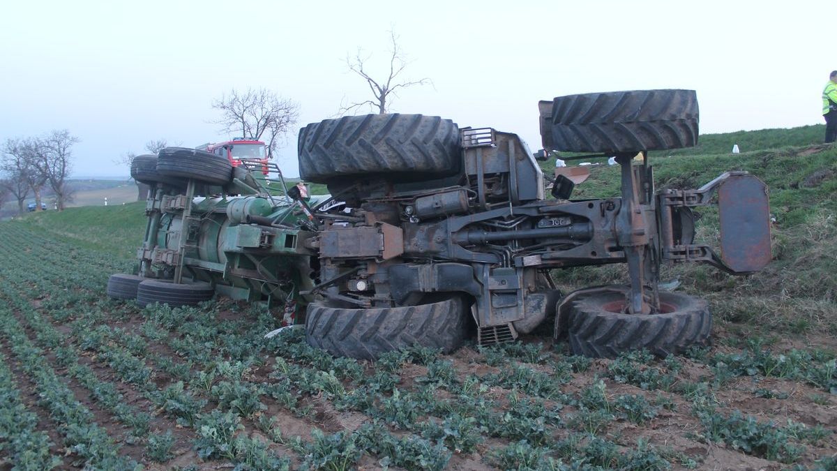 Převrácený traktor skončil mimo vozovku. 