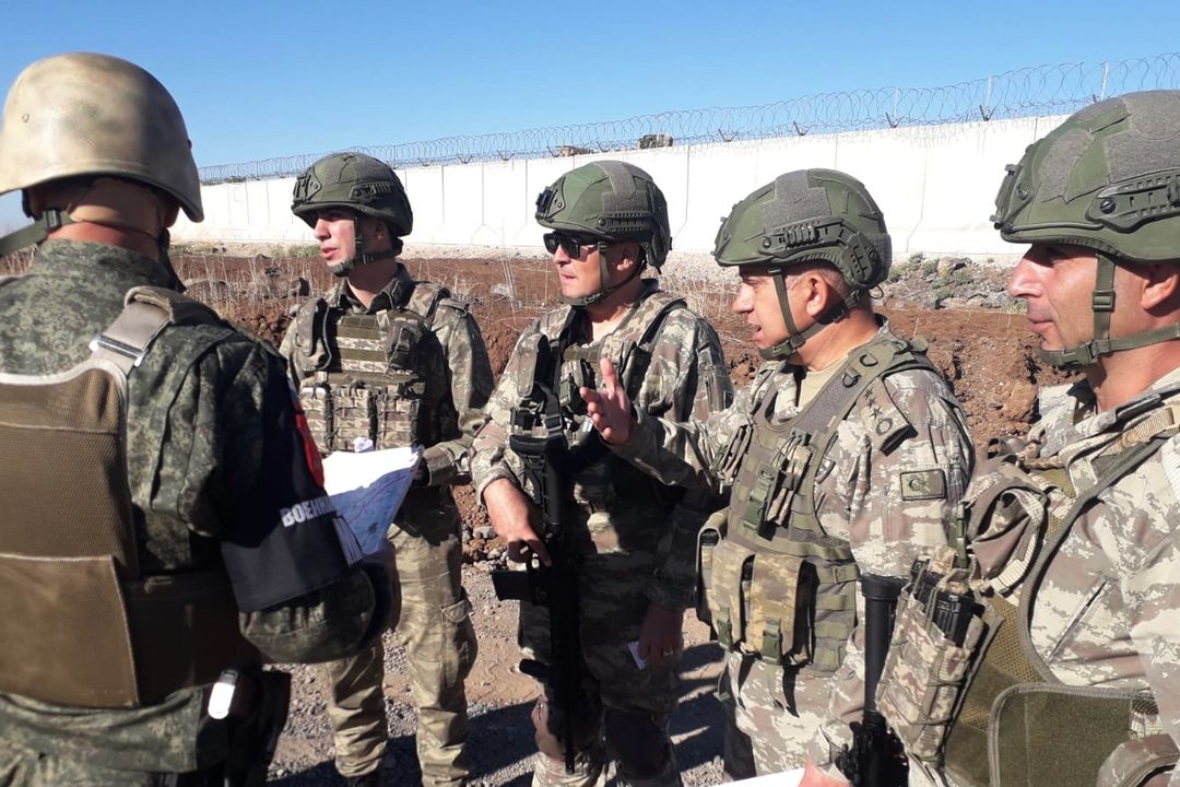 Turečtí vojáci (vpravo) mluví před společnou hlídkou na severu Sýrie s ruským