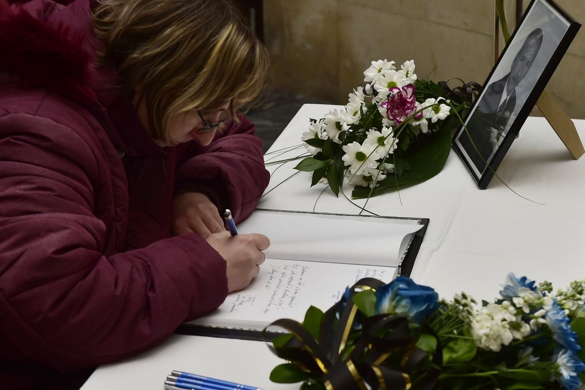 Žena v budově teplického magistrátu zapisuje vzkaz do kondolenční knihy na památku předsedy Senátu Jaroslava Kubery