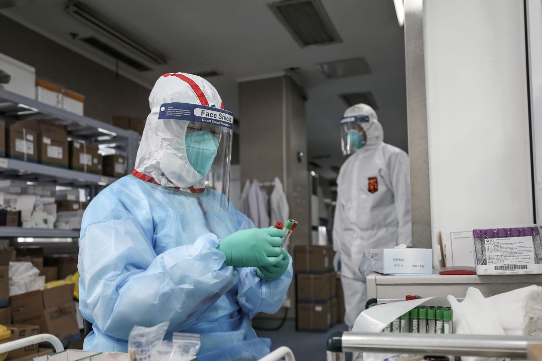 Zdravotník ve Wu-chanu dělá test RNA na nákazu koronavirem 