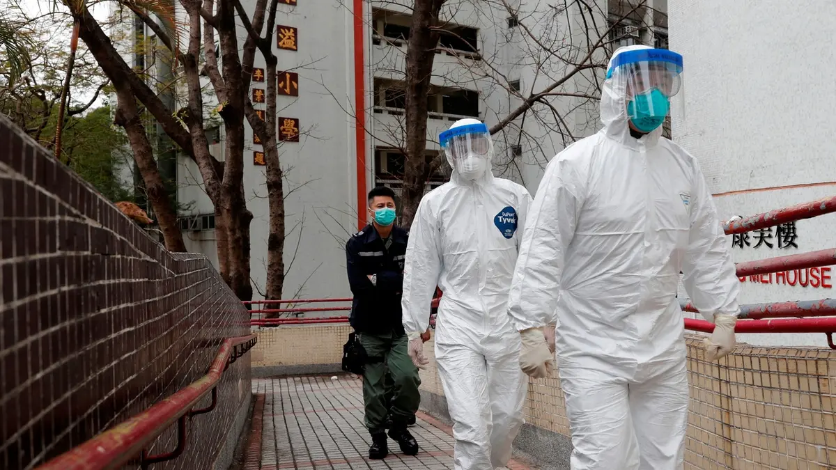 Zdravotníci v ochranných oděvech evakuují nakažené z domu Hong Mei v Hongkongu 