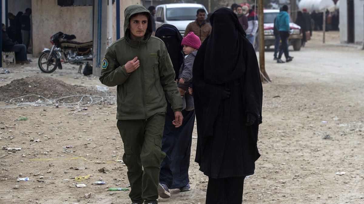 Kurdská bojovnice vedle manželky radikála Islámského státu v táboře Al-Hol na severu Sýrie