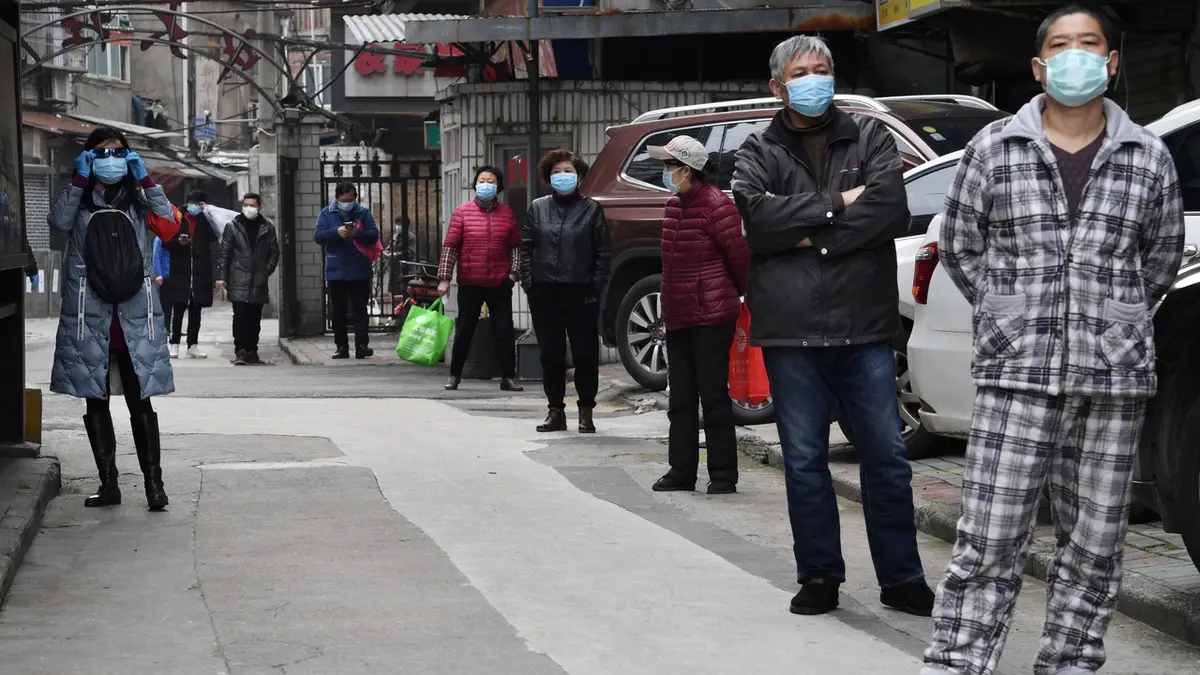 Obyvatelé Wu-chanu čekají na ulici na dodávku zeleniny.