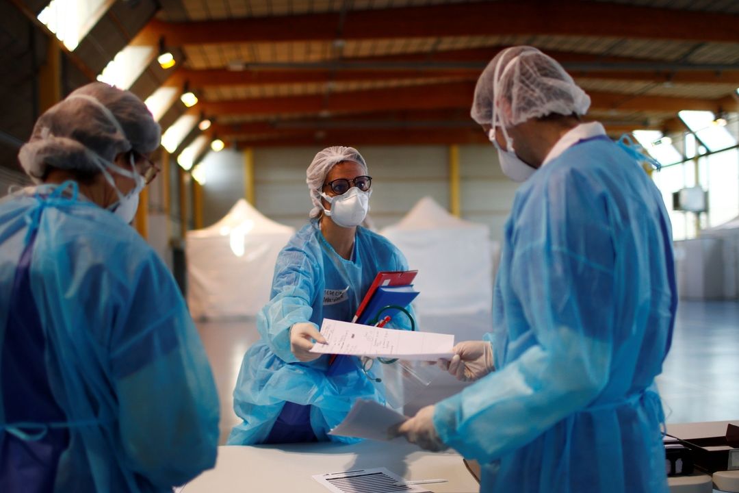 Zdravotníci v ochranných oděvech na urgentním přijmu v gymnáziu v Taverny u Paříže 