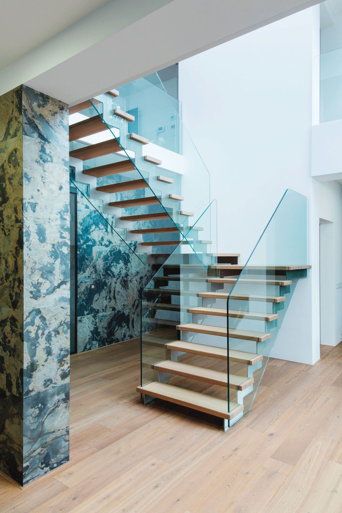 Skleněná výplň místo klasického zábradlí odlehčuje celkový dojem ze segmentového schodiště, prosvětluje efektně prostor.