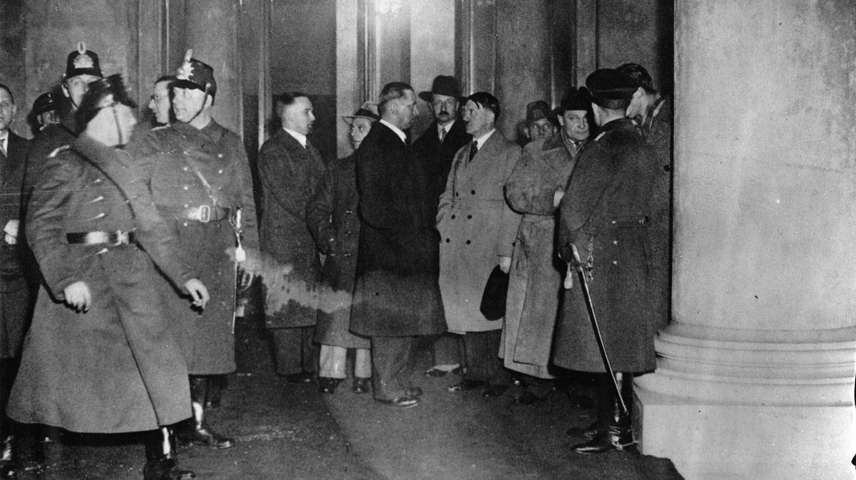 Před hořícím Říšským sněmem se jako první nacistický potentát objevil Hermann Göring (druhý zprava, v klobouku) a posléze i samotný Adolf Hitler (po pravici Göringa).
