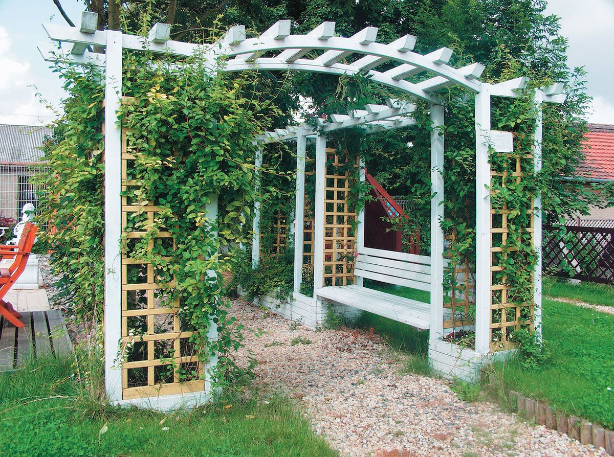 Dřevěná pergola s květináči vytvoří na zahradě romantické zákoutí. 