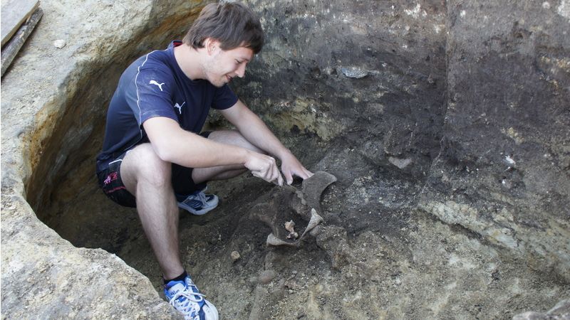 Člen výzkumného týmu u místa objevu zvířecí kostry.