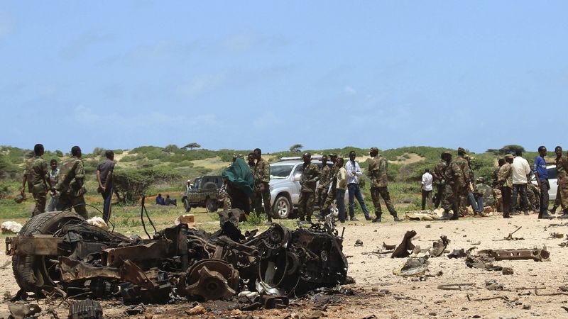 Místní milice a obyvatelé na místě srpnového atentátu u výcvikového tábora u přístavu Kismayu