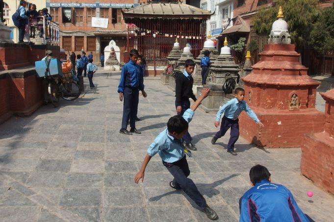 Školáci si krátí dlouhou chvíli fotbálkem mezi chrámy