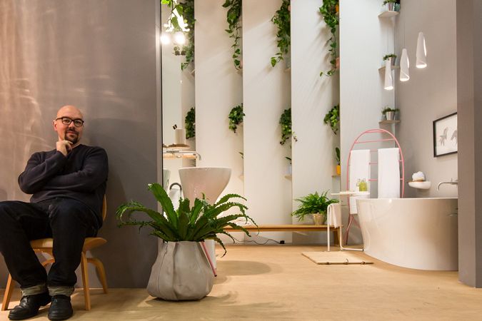 Autor návrhu Luca Nichetto ve svém interiéru plném rostlin na veletrhu.