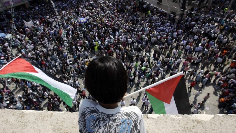Palestinský chlapec sleduje dav lidí, který se v městě Ramalláh shromáždil na podporu vzniku samostatného státu. 