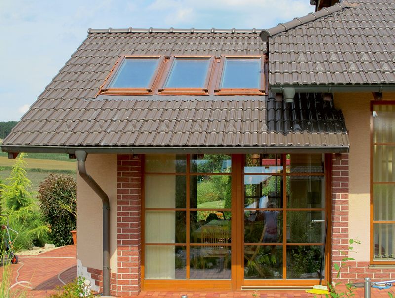 Trojice střešních oken v měděném provedení je pěkně sladěná s fasádou a stylem rodinného domu.