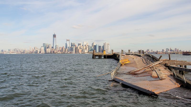 Hurikán Sandy si s ostrovem, na němž socha stojí, nepěkně pohrál. Takhle to odnesl jeden z doků.