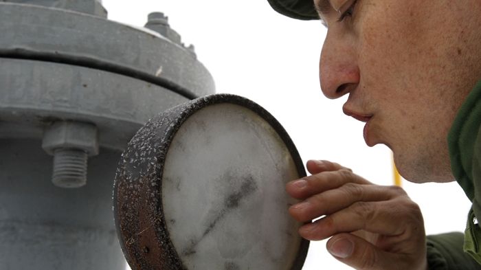 Zaměstnanec slovenských plynáren čistí namrzlé sklo měřáku, který ukazuje nulový tlak plynu.
