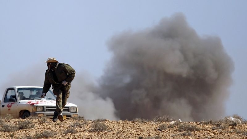 Libyjský vzbouřenec utíká před ostřelováním vládními vojsky. 