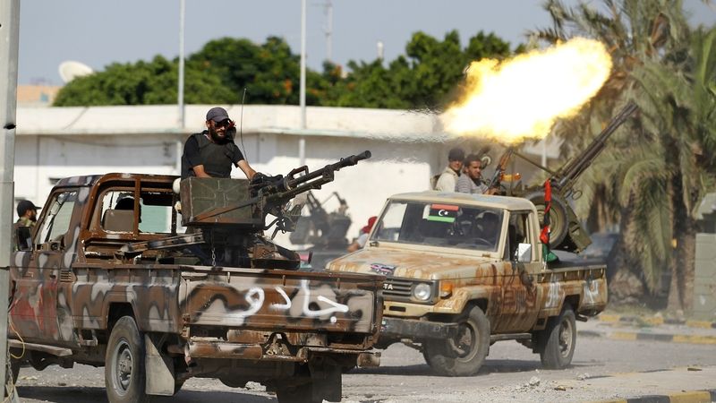Libyjští povstalci střílí z aut směrem ke Kaddáfího komplexu Báb al-Azízíja.